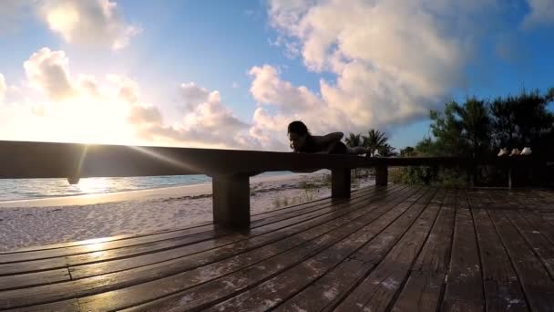 Mladá žena, která dělá jógu na pláži — Stock video