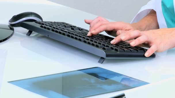 Doctora escribiendo en el teclado de la computadora — Vídeo de stock