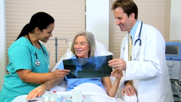 Paciente olhando imagens de raios-x com a equipe do radiologista — Vídeo de Stock
