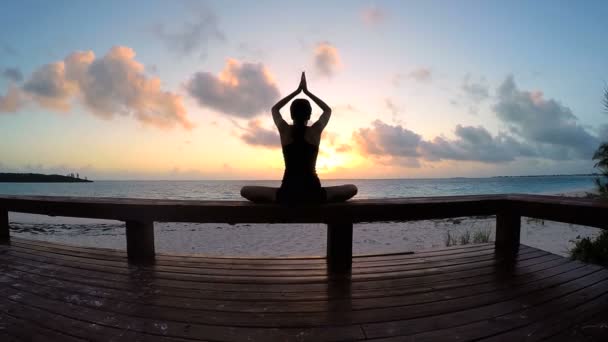 Ung kvinna gör yoga på en strand — Stockvideo