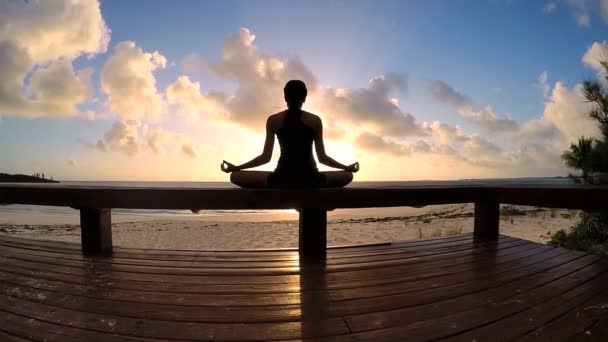 Mujer joven haciendo yoga en una playa — Vídeos de Stock