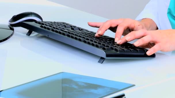 Female doctor typing on computer keyboard — Stock Video