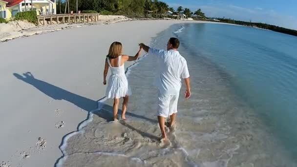 Caucásico pareja caminando en arenosa playa — Vídeos de Stock