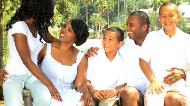 Famille afro-américaine sur banc dans le jardin — Video