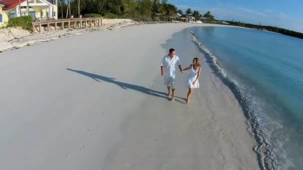 Caucásico pareja caminando en arenosa playa — Vídeos de Stock