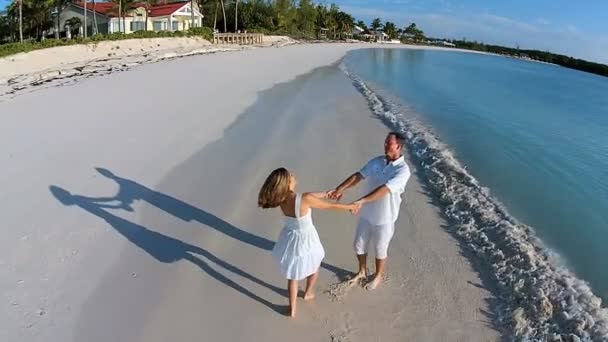 Caucásico pareja caminando en arenosa playa — Vídeos de Stock