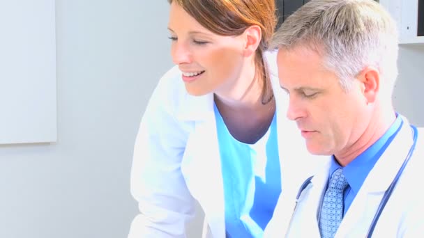 Médicos que trabajan juntos en consultorio médico — Vídeos de Stock