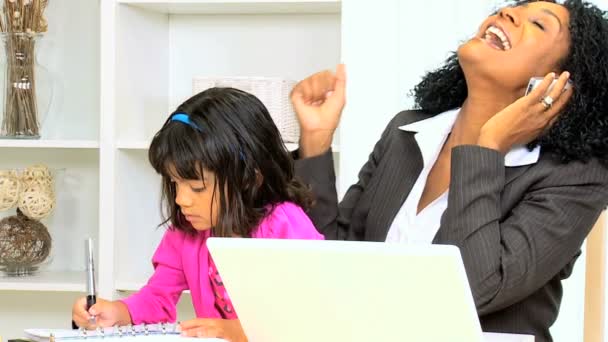 Жінка працює вдома зі своєю дочкою — стокове відео