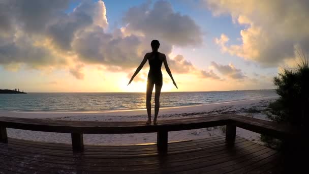 Mujer joven haciendo yoga en una playa — Vídeo de stock