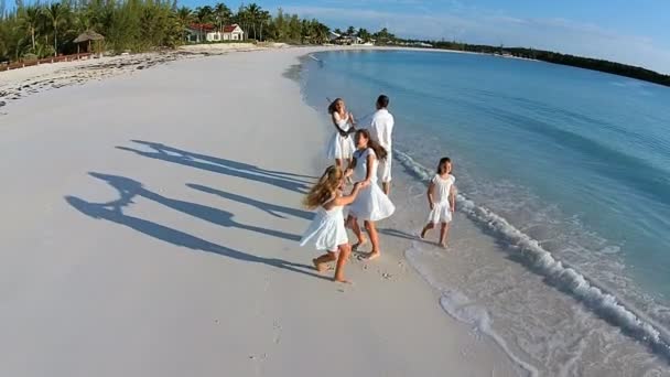 Familia caucásica caminando en la playa de arena — Vídeo de stock