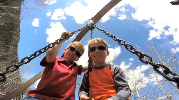 Young boys swinging on swing — Stock Video
