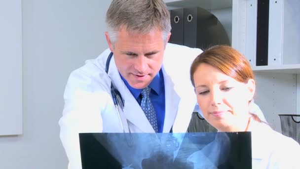 男性和女性医生讨论 x 射线测试 — 图库视频影像