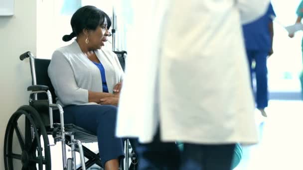 Νοσοκόμα με τον ασθενή σε αναπηρική καρέκλα, συμβουλευτικές υπηρεσίες στο νοσοκομείο — Αρχείο Βίντεο