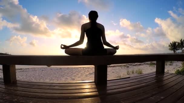 Mujer joven haciendo yoga en una playa — Vídeos de Stock