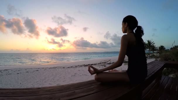 Jonge vrouw doet yoga op een strand — Stockvideo