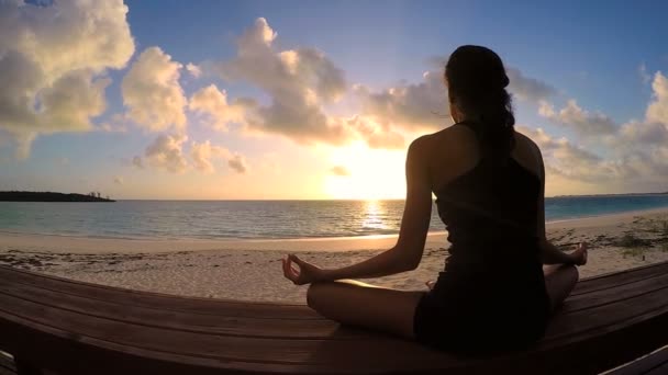 Jonge vrouw doet yoga op een strand — Stockvideo