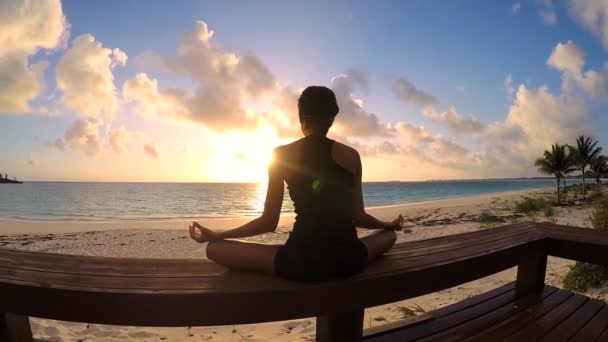 Jonge vrouw doet yoga op een strand — Stockvideo