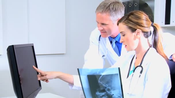 Manliga och kvinnliga läkare diskuterar röntgen tester — Stockvideo