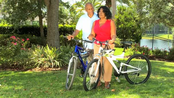 Etnico coppia anziana mantenendo in forma su biciclette — Video Stock
