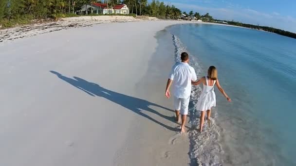 Caucásico pareja caminando en arenosa playa — Vídeo de stock