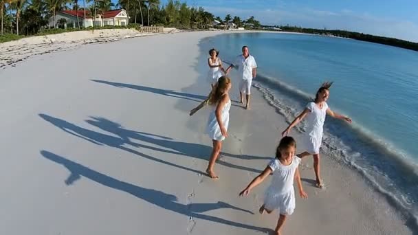 Familia caucásica caminando en la playa de arena — Vídeo de stock