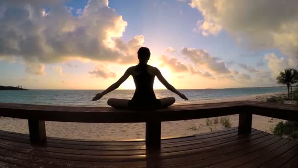 Jeune femme faisant du yoga sur une plage — Video