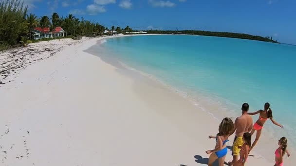 Familia caucásica caminando en la playa de arena — Vídeo de stock