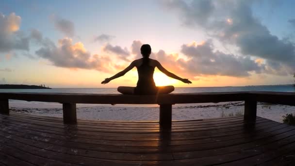 Ung kvinna gör yoga på en strand — Stockvideo