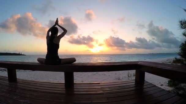 Jonge vrouw doet yoga op een strand — Stockvideo