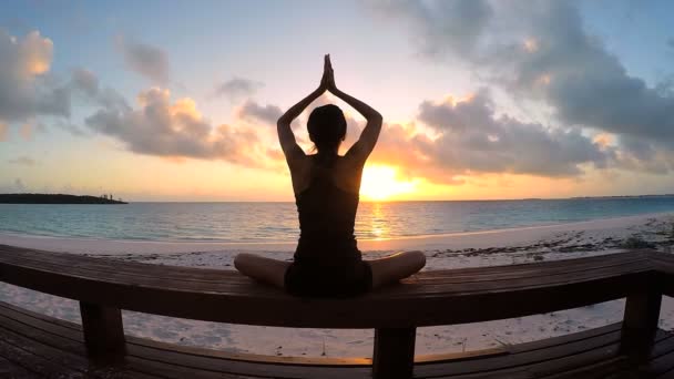 Young woman doing yoga on a beach — Stock Video