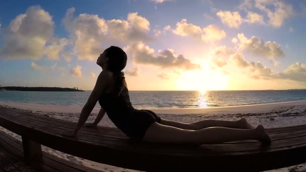 Молодая женщина занимается йогой на пляже — стоковое видео