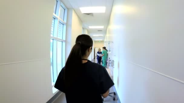 Γυναίκα γιατρό περπάτημα σε διάδρομο στο ιατρικό κέντρο — Αρχείο Βίντεο