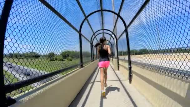 Femme afro-américaine jogging sur passerelle clôturée — Video