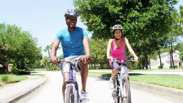 Pareja montando sus bicicletas en el parque — Vídeos de Stock