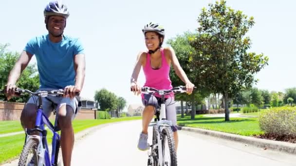 Pareja montando sus bicicletas en el parque — Vídeo de stock