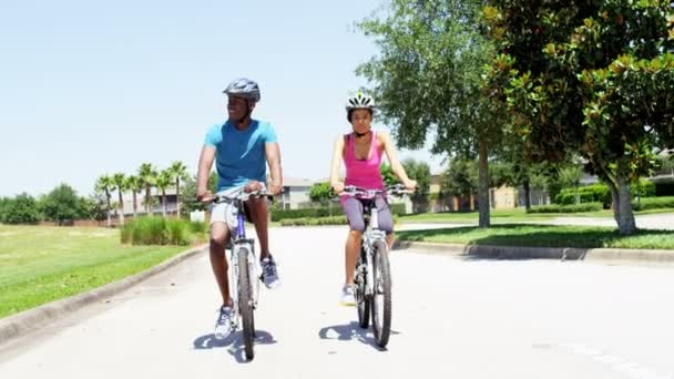 Paar rijden hun fietsen in park — Stockvideo