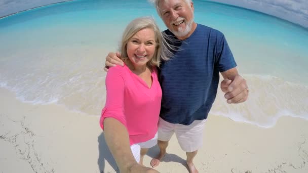 Kaukasische senioren nemen van selfie op strand — Stockvideo