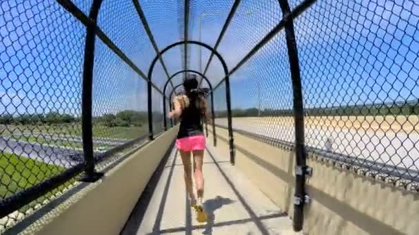 Femme afro-américaine jogging sur passerelle clôturée — Video