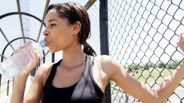 Woman runner drinking water on bridge — Stock Video