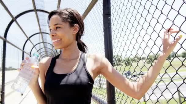 Woman runner drinking water on bridge — Stock Video