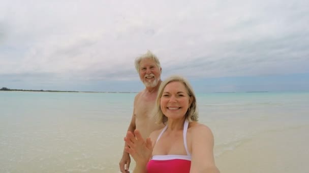 Kaukázusi idősek, figyelembe véve a selfie strandon — Stock videók