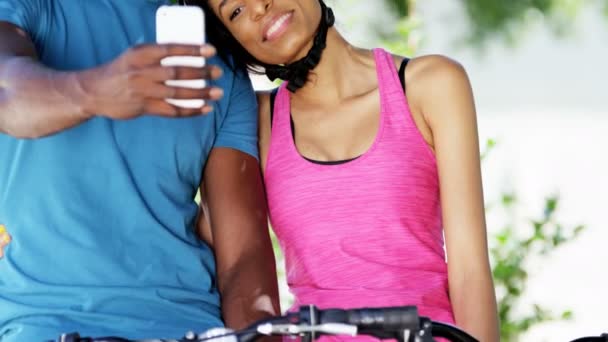 Pareja tomando selfie mientras monta en bicicleta — Vídeo de stock
