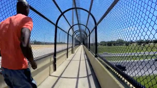 Afro-Américain jogging sur passerelle clôturée — Video