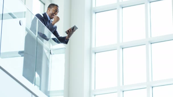 Hombre de negocios utilizando la tableta inalámbrica en el edificio de oficinas — Vídeos de Stock