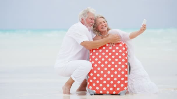 Senior couple taking photos on beach — Stock Video