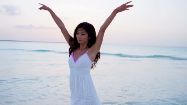 Chinees meisje in witte jurk dansen op strand — Stockvideo