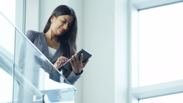 Mujer de negocios utilizando la tableta inalámbrica en el edificio de oficinas — Vídeo de stock