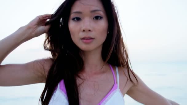 Fille chinoise en robe blanche dansant sur la plage — Video