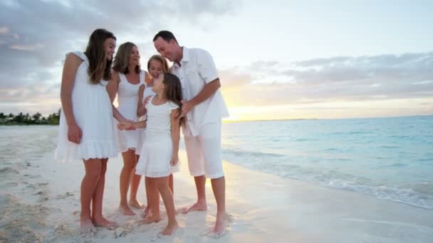 Familia caucásica disfrutando de vacaciones en la playa al atardecer — Vídeos de Stock