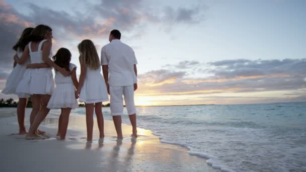 Familia caucásica disfrutando de vacaciones en la playa al atardecer — Vídeo de stock